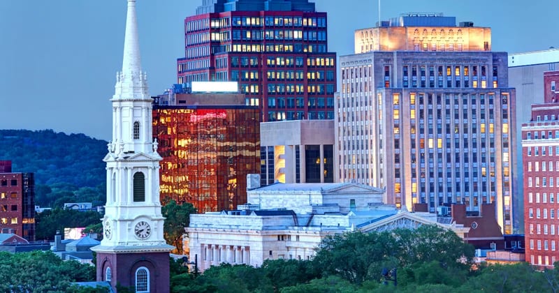 The New Haven skyline at dusk, with the Green's church steeple in front
