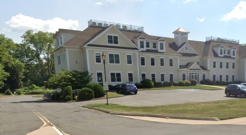 The three-story office building at 680 South Main Street in Cheshire, with a parking lot in front