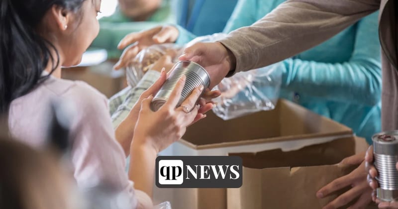 Volunteers pass canned food into boxes at a food drive
